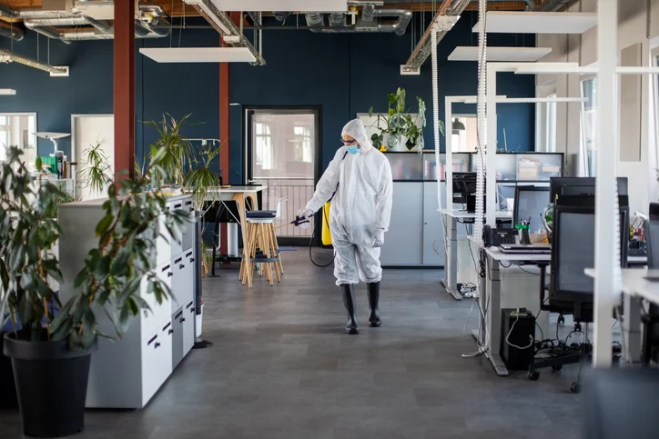 Sanitation worker disinfecting the office area