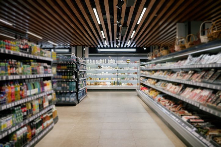 Shopping Along Shelves in Modern Supermarket Aisle